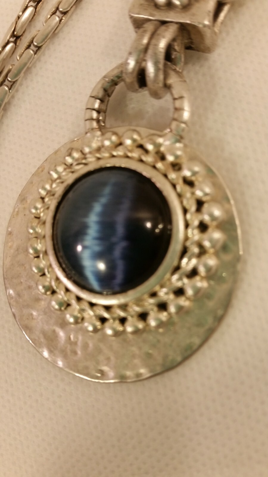 Blue Tiger Eye Cabochon style pendant with a convex formed silver toned reverse