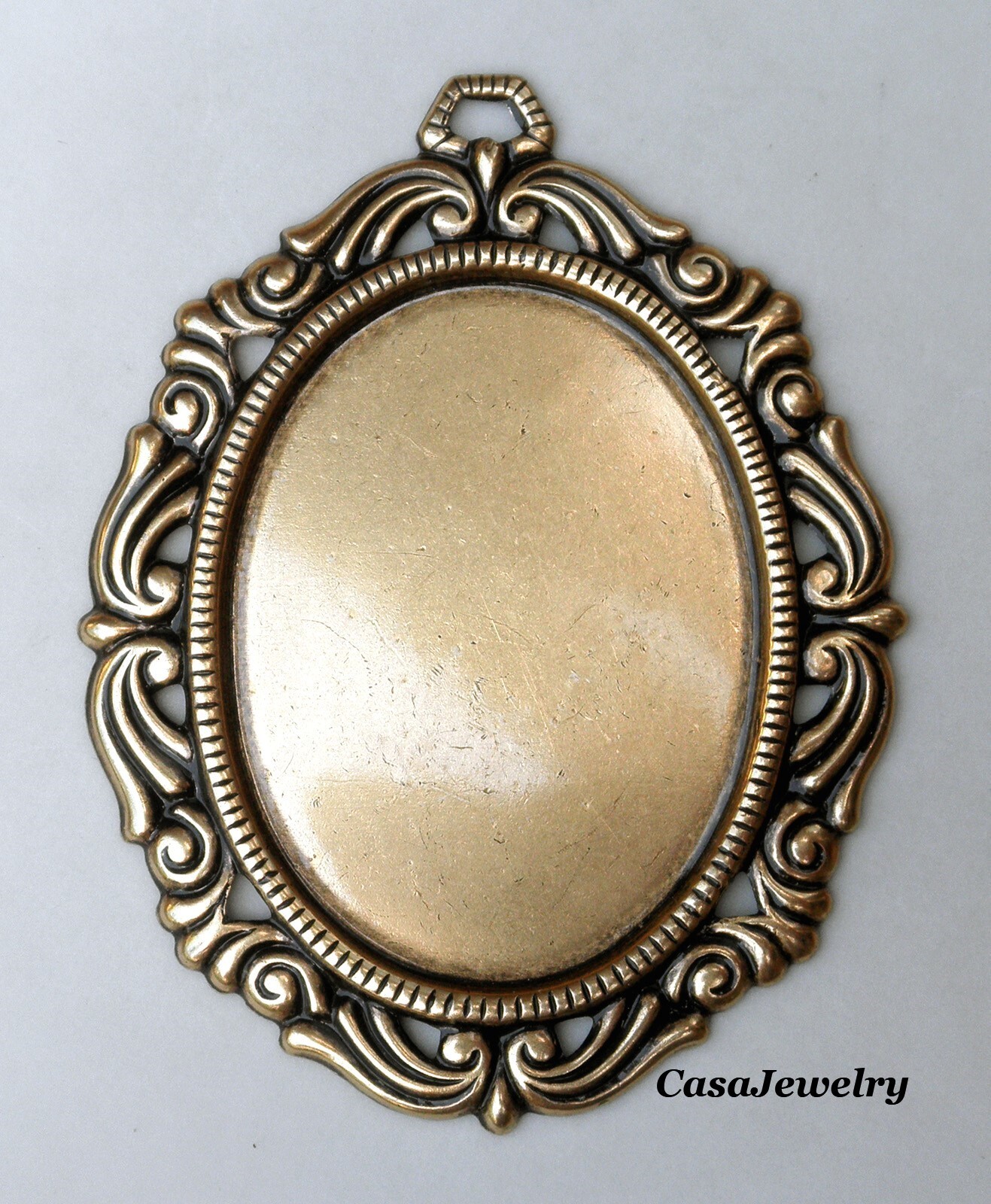 #1793 ANTIQUED GOLD 40×30 FILIGREE BORDERED BEZEL W/TOP HANG RING – 1 Pc