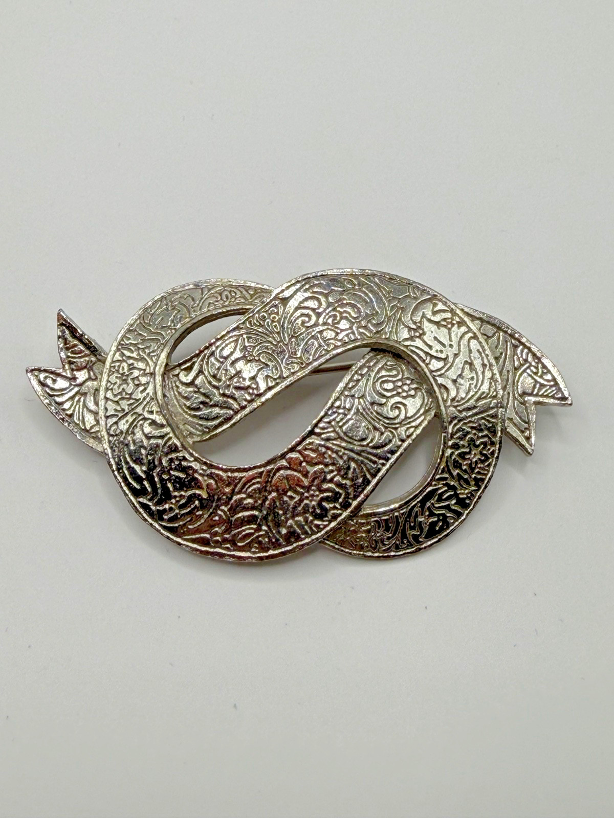 VINTAGE SILVER TONE BOW IN DOLLAR SIGN LIKE SHAPE BROOCH