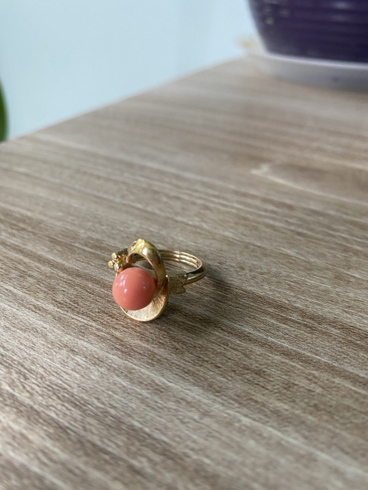 Avon vintage gold toned ring showcasing a single faux coral-colored bead.