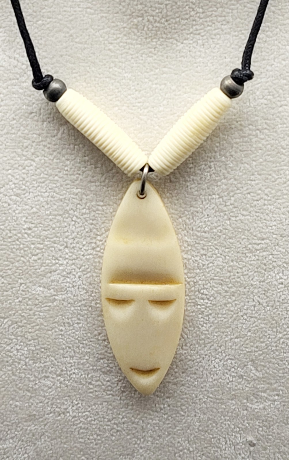 Vintage 18″ vinyl necklace with shield shape bone face pendant