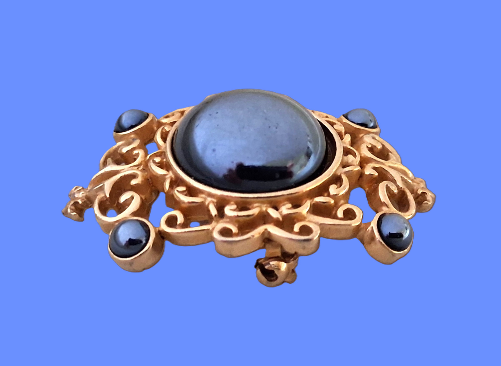 Vintage Filigree Brooch with a rich dark gray domed mirror-finished center stone