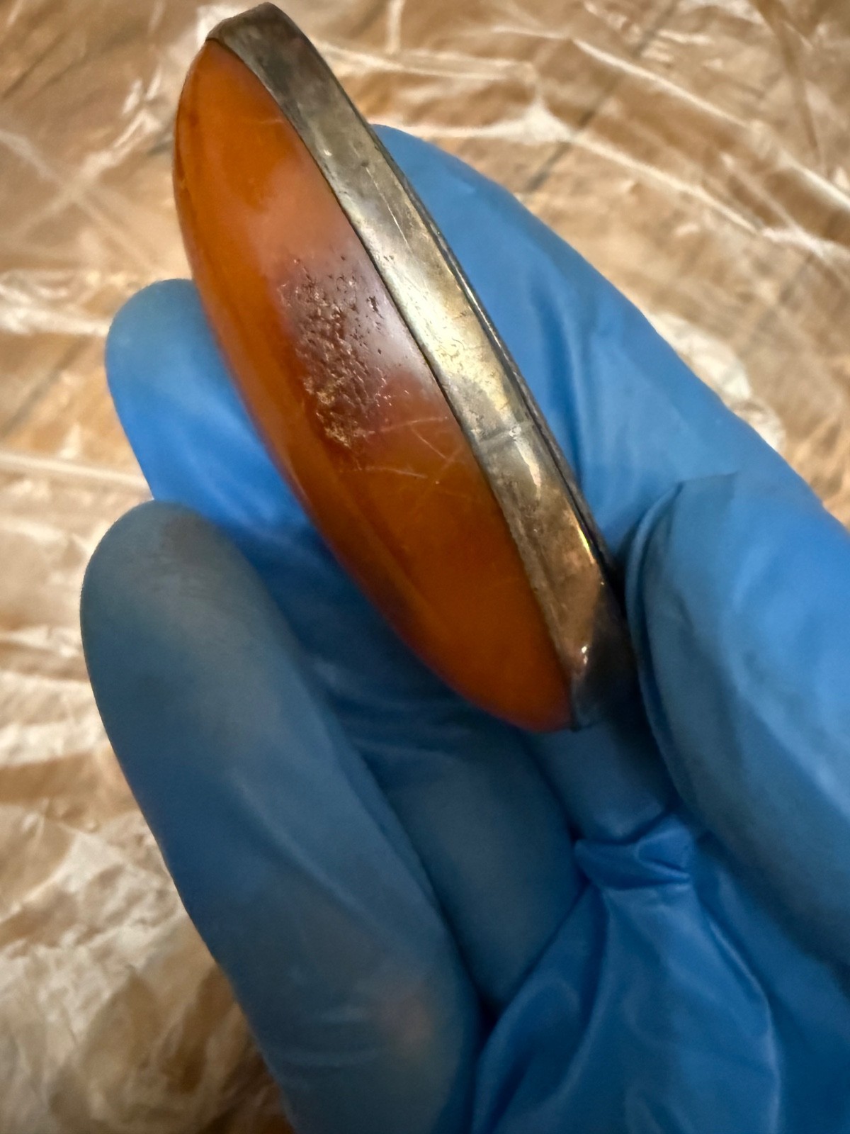 vintage sterling silver brooch features a large, warm-toned amber cabochon set