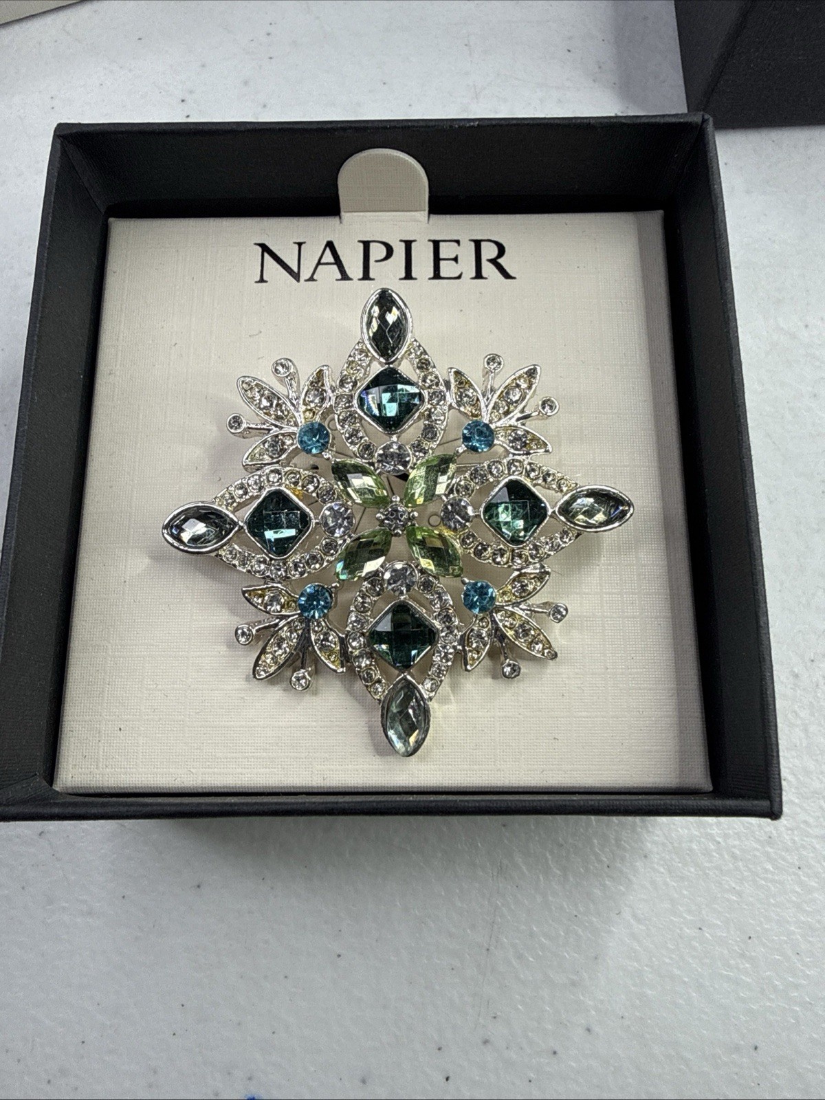 Napier silver-tone snowflake pin/brooch featuring blue and green rhinestones NOS