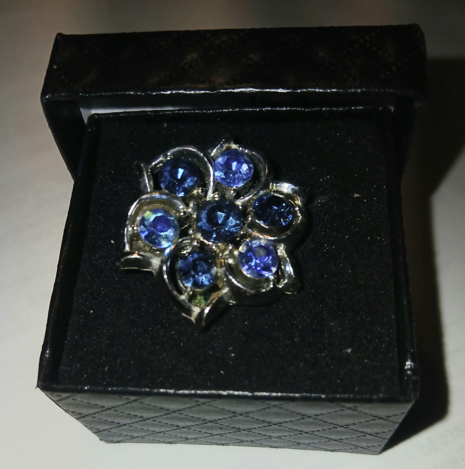 Blue crystals in silver metal setting round brooch/pin