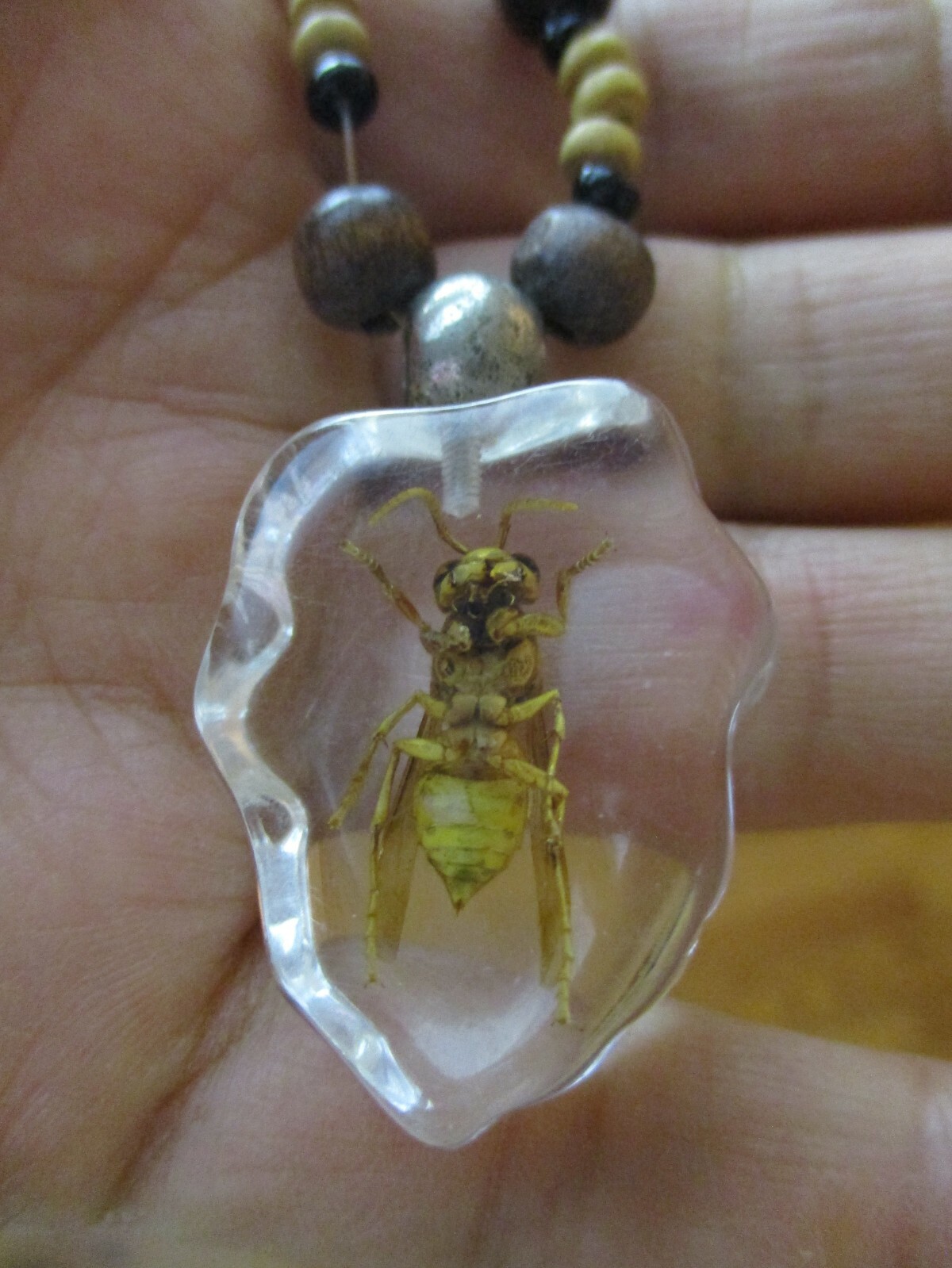 Necklace with bee coated plastic insect acrylic wood bead