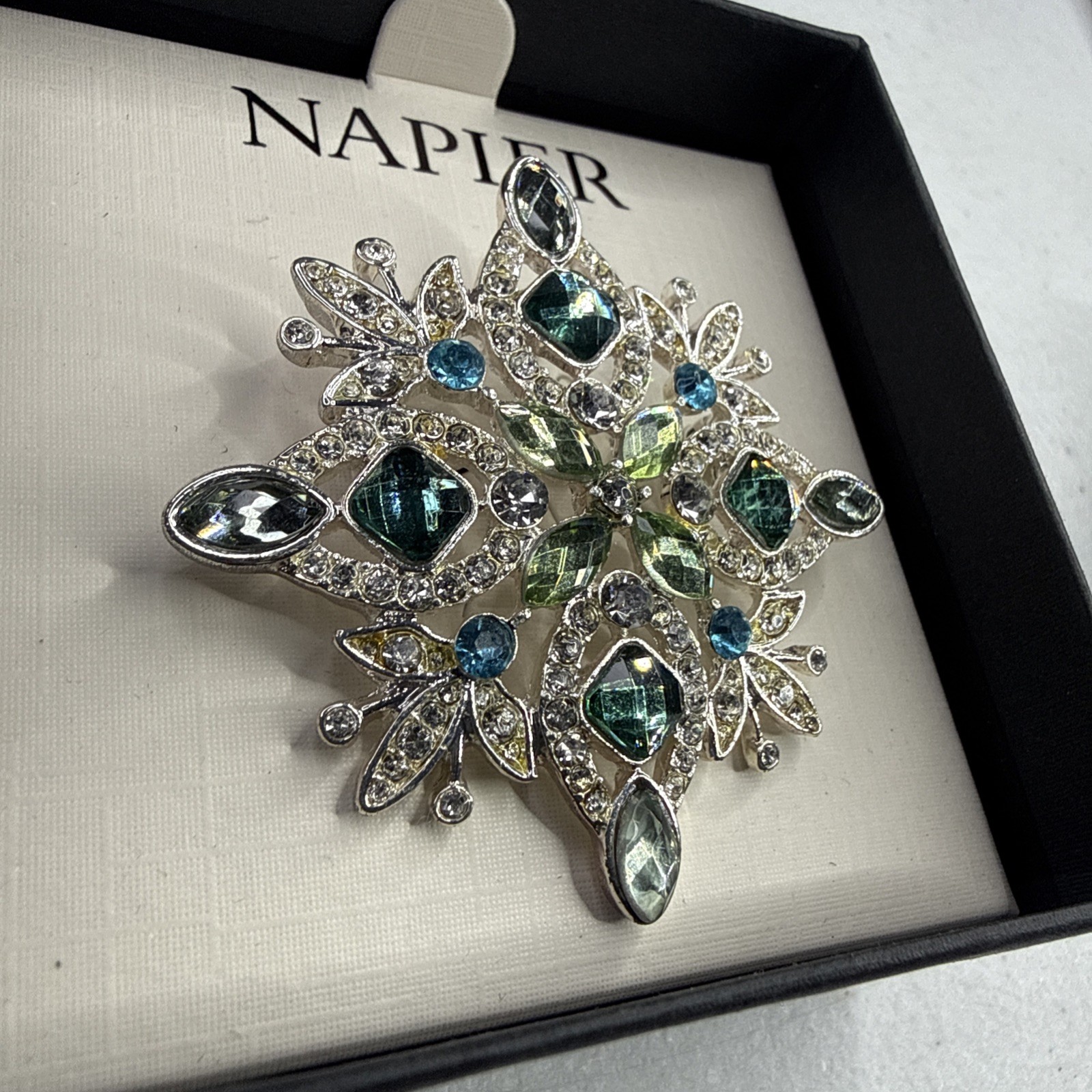 Napier silver-tone snowflake pin/brooch featuring blue and green rhinestones NOS