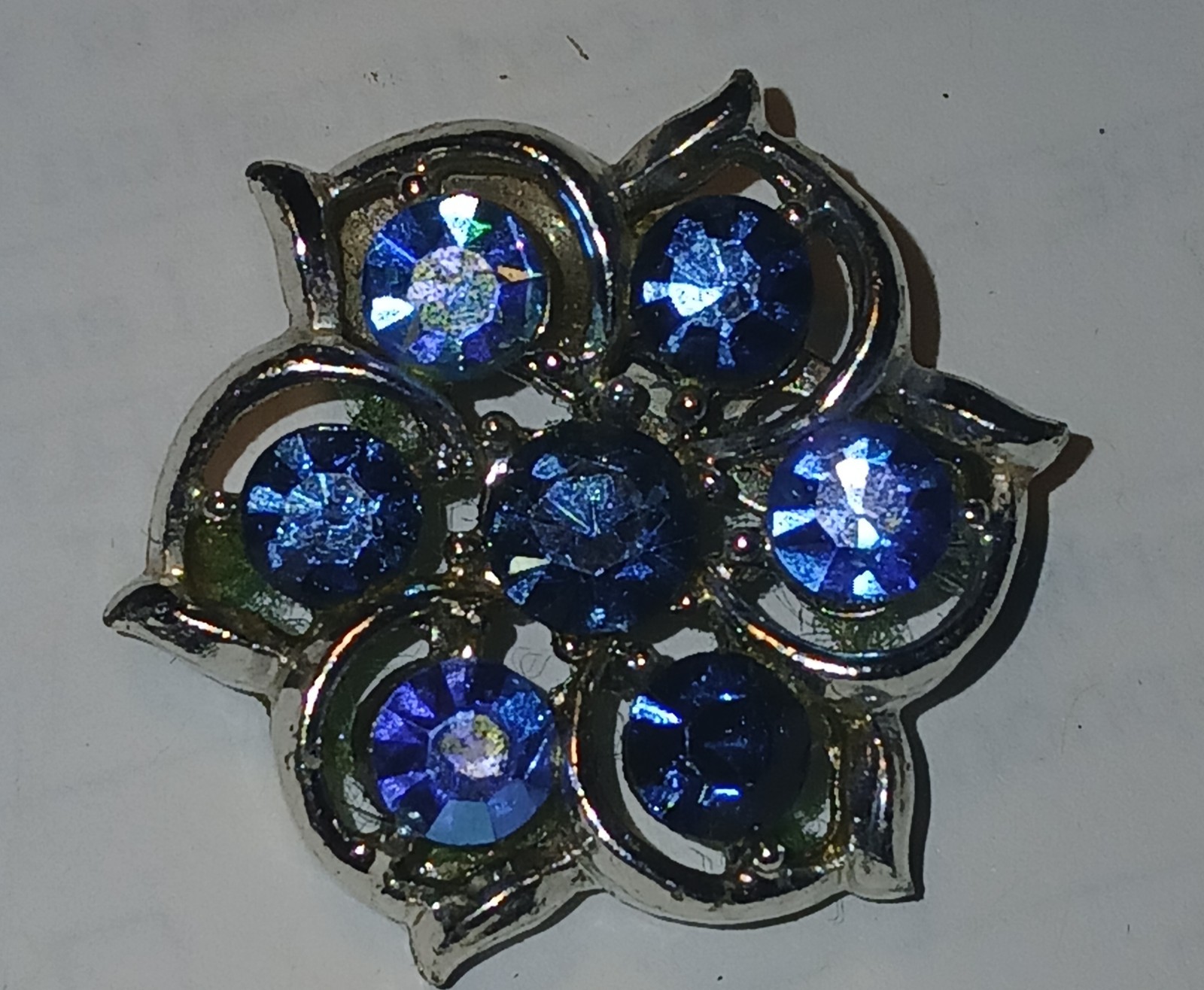 Blue crystals in silver metal setting round brooch/pin