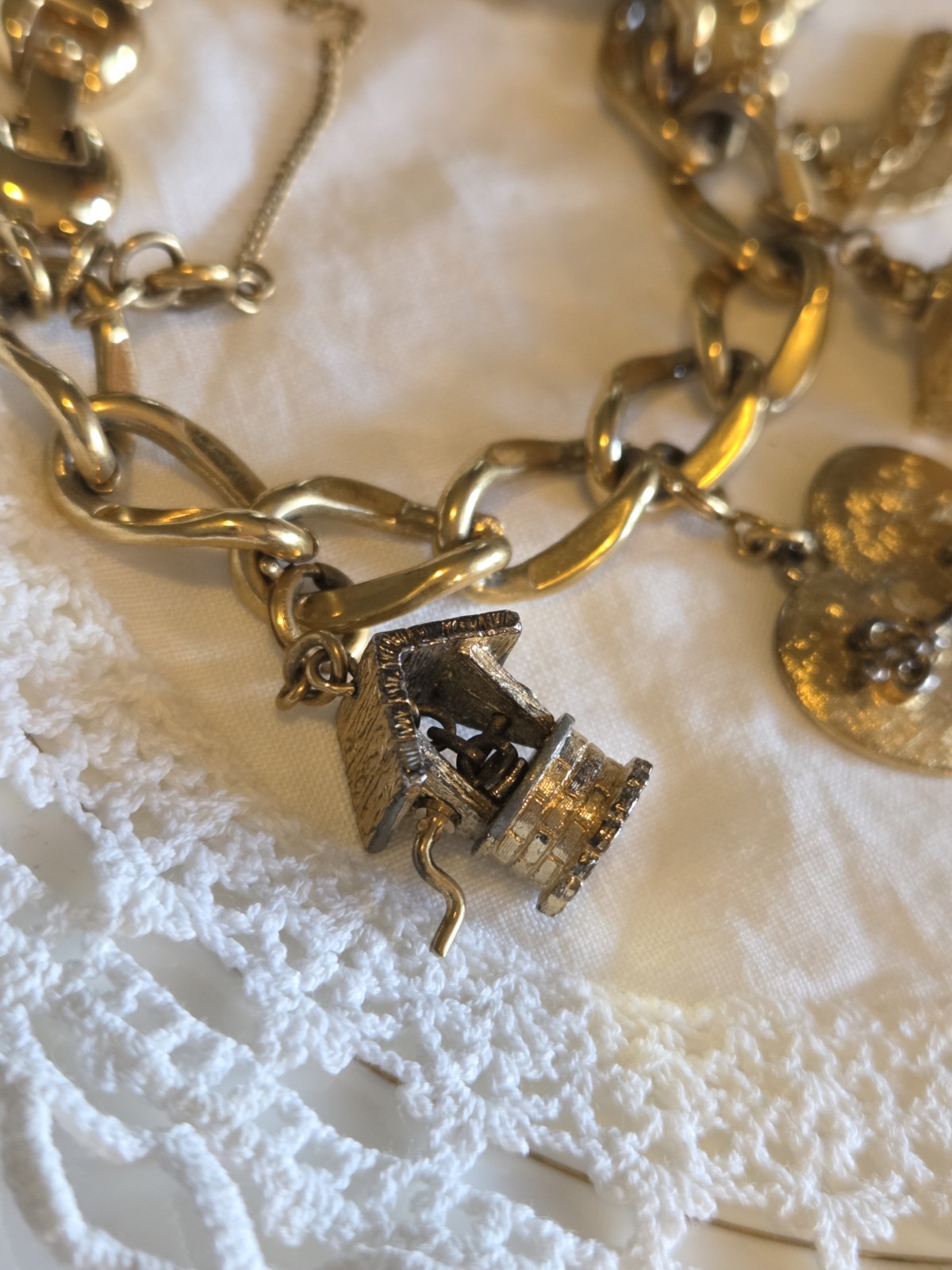 vintage Monet gold-tone charm bracelet features multiple detailed charms
