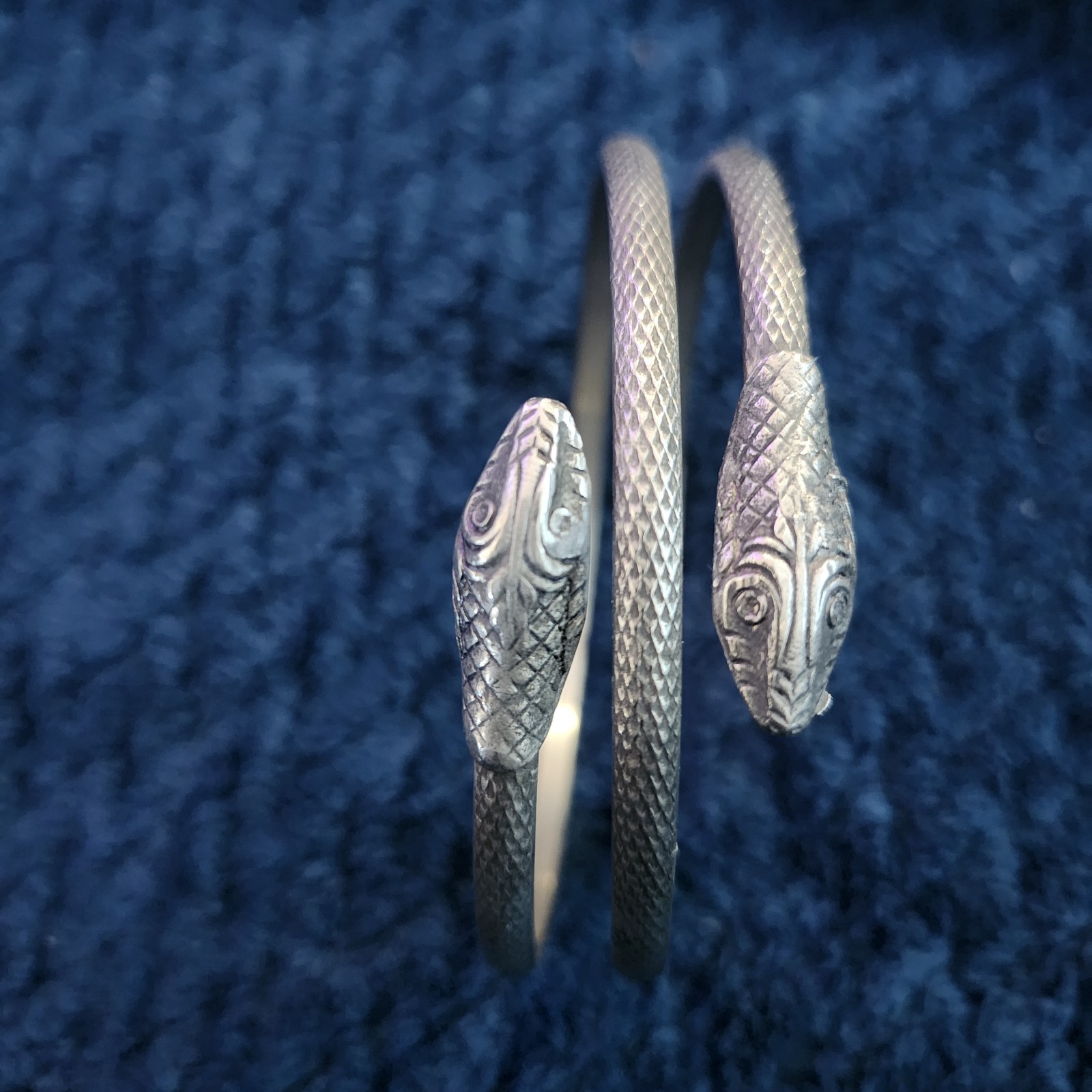 vintage-style oxidized silver snake bracelet is designed to coil around the Arm