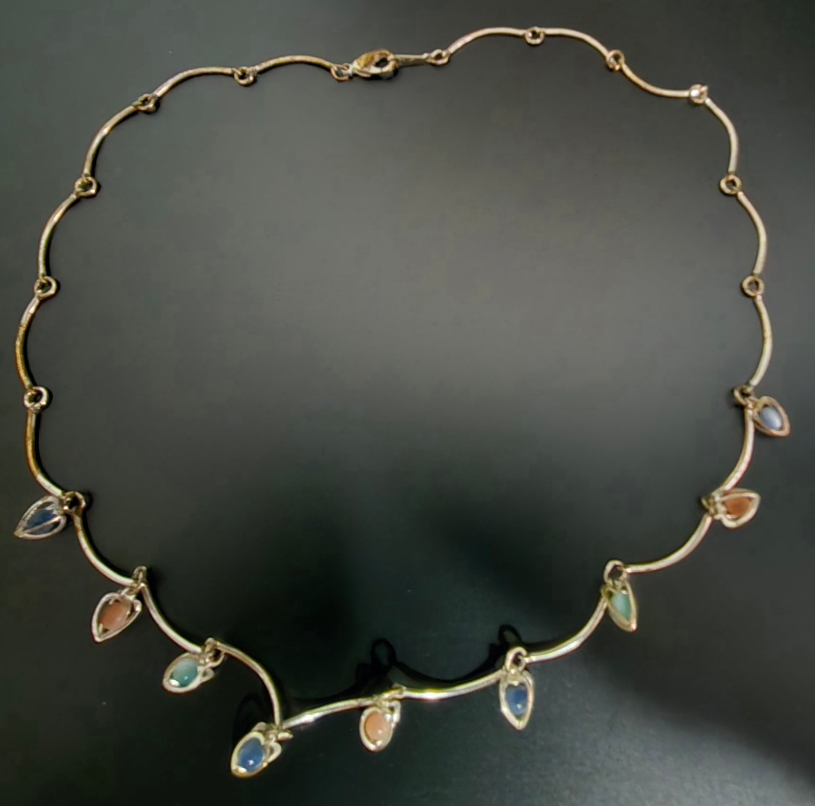 9 multicolor heart caged bead charms on a silvertone necklace