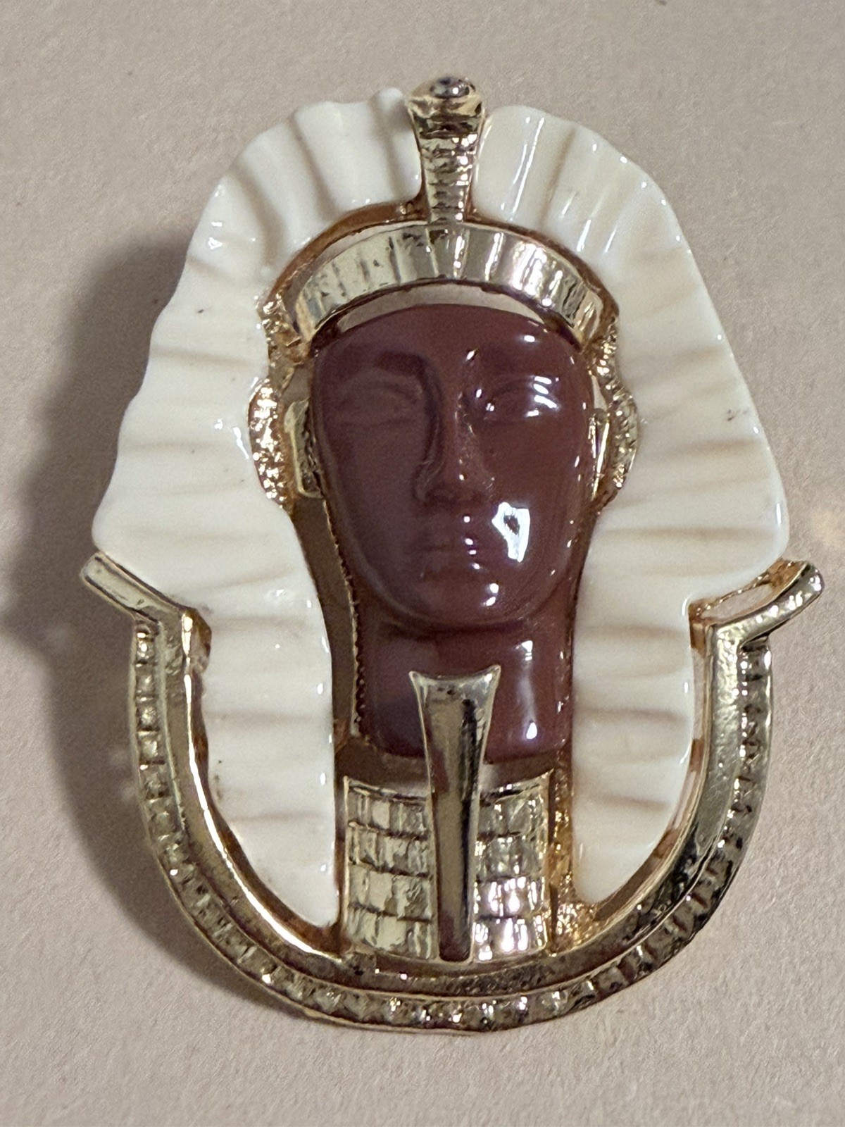 Egyptian Revival King Tut brooch featuring gold metal, white lucite, red resin