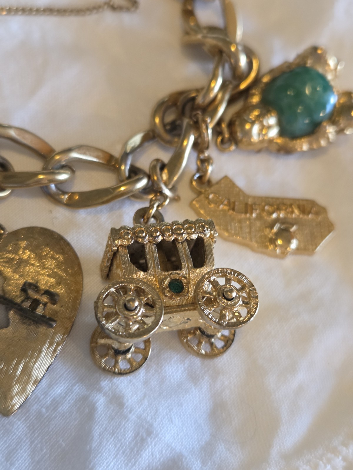 vintage Monet gold-tone charm bracelet features multiple detailed charms