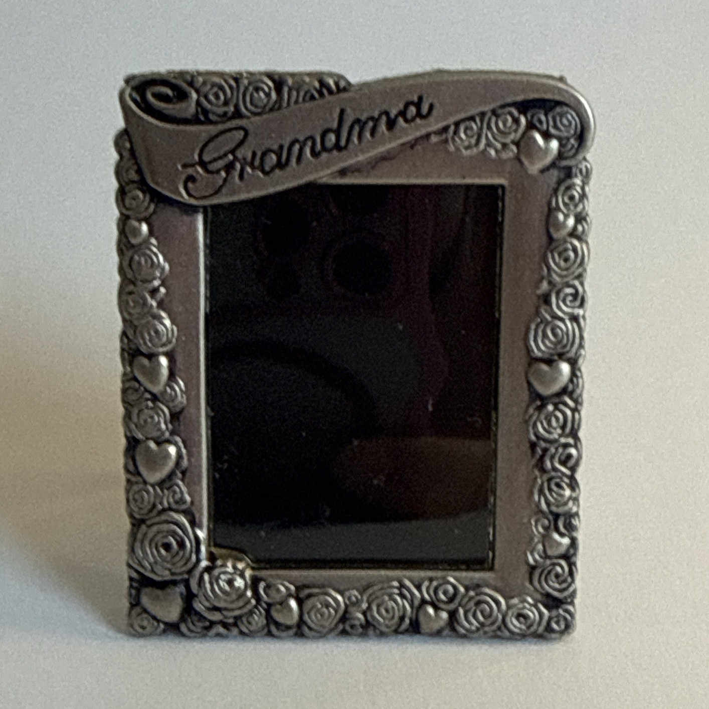 vintage pewter grandma frame brooch features a decorative border of roses and he