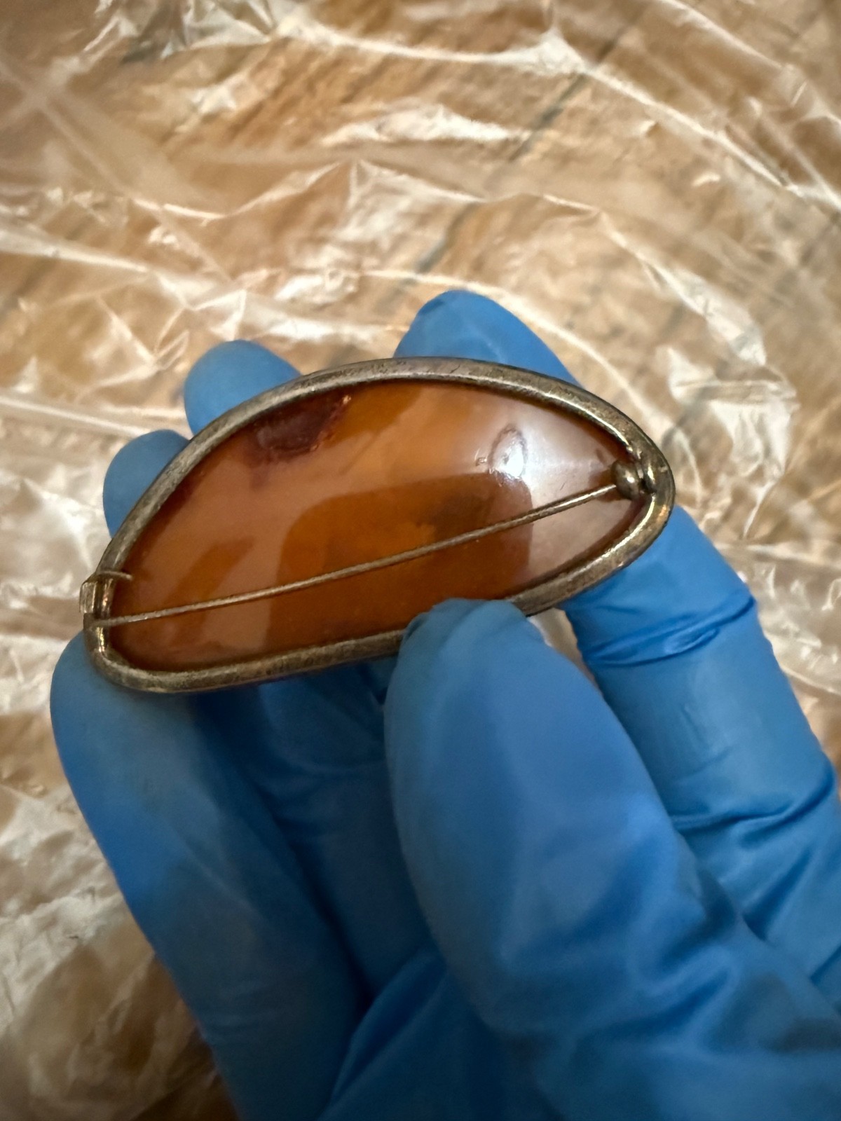 vintage sterling silver brooch features a large, warm-toned amber cabochon set