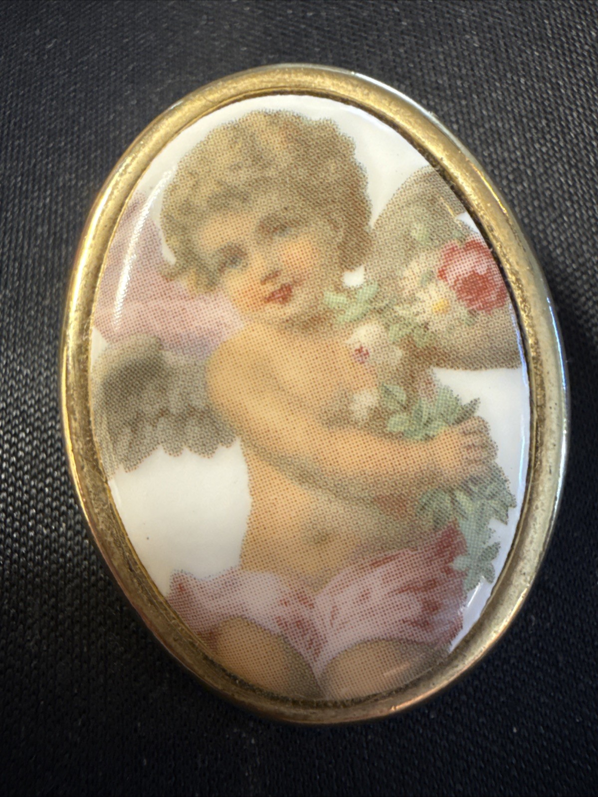 Vintage porcelain cherub or angel brooch with a gold-toned frame. 1 1/2 “
