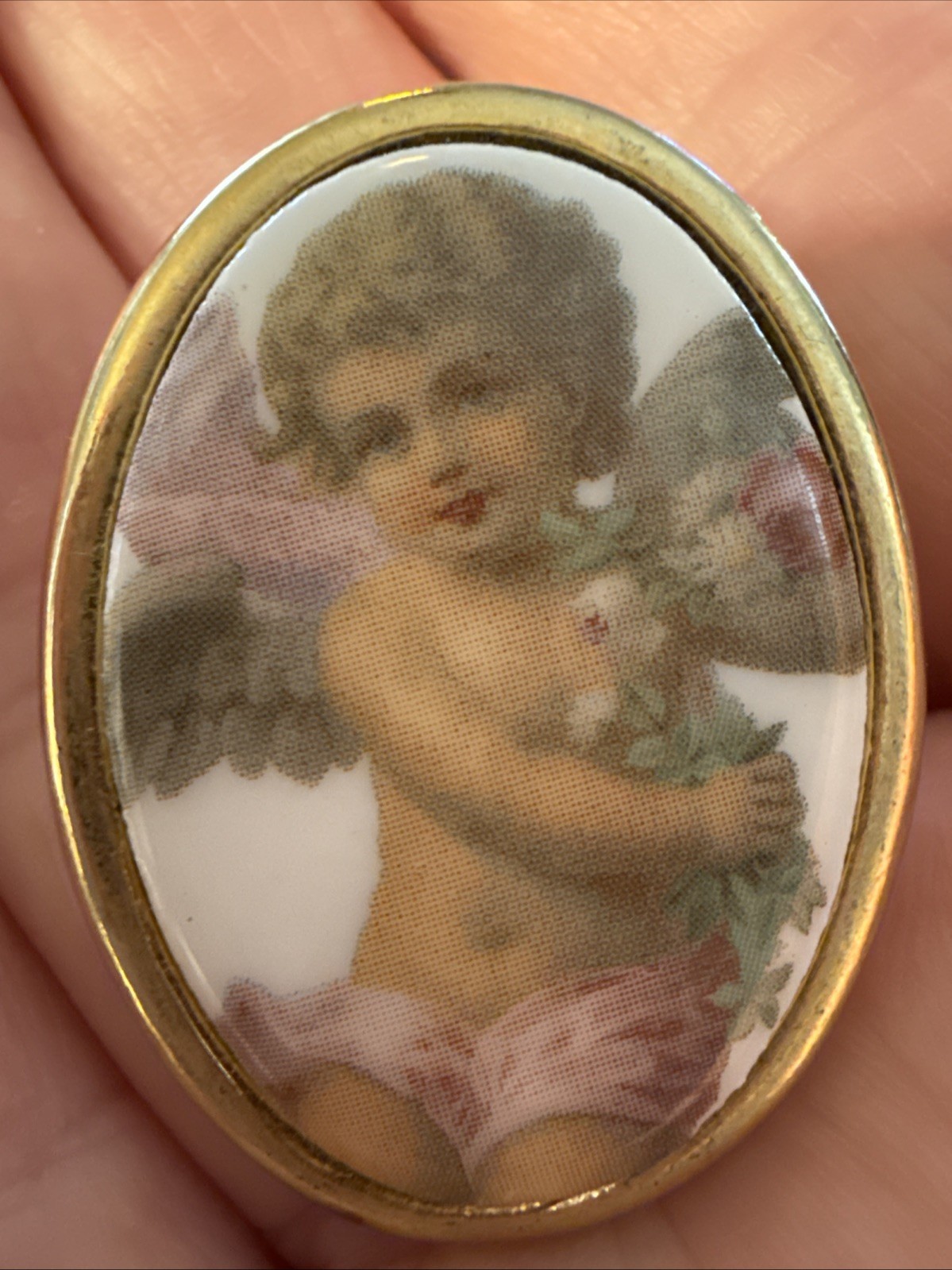 Vintage porcelain cherub or angel brooch with a gold-toned frame. 1 1/2 “