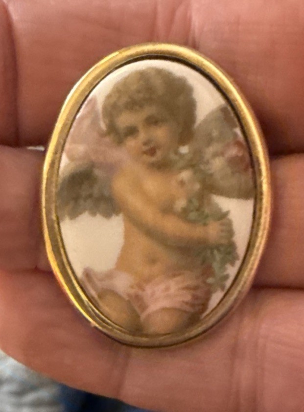 Vintage porcelain cherub or angel brooch with a gold-toned frame. 1 1/2 “