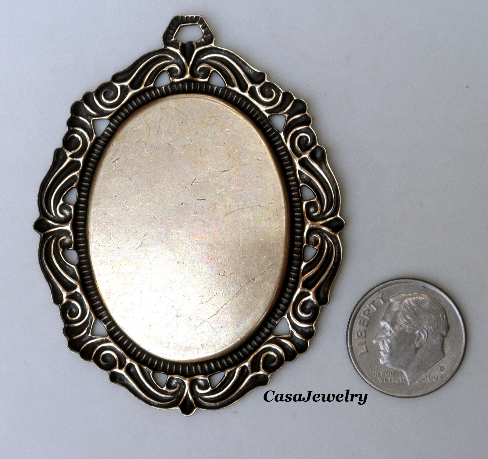 #1793 ANTIQUED GOLD 40×30 FILIGREE BORDERED BEZEL W/TOP HANG RING – 1 Pc