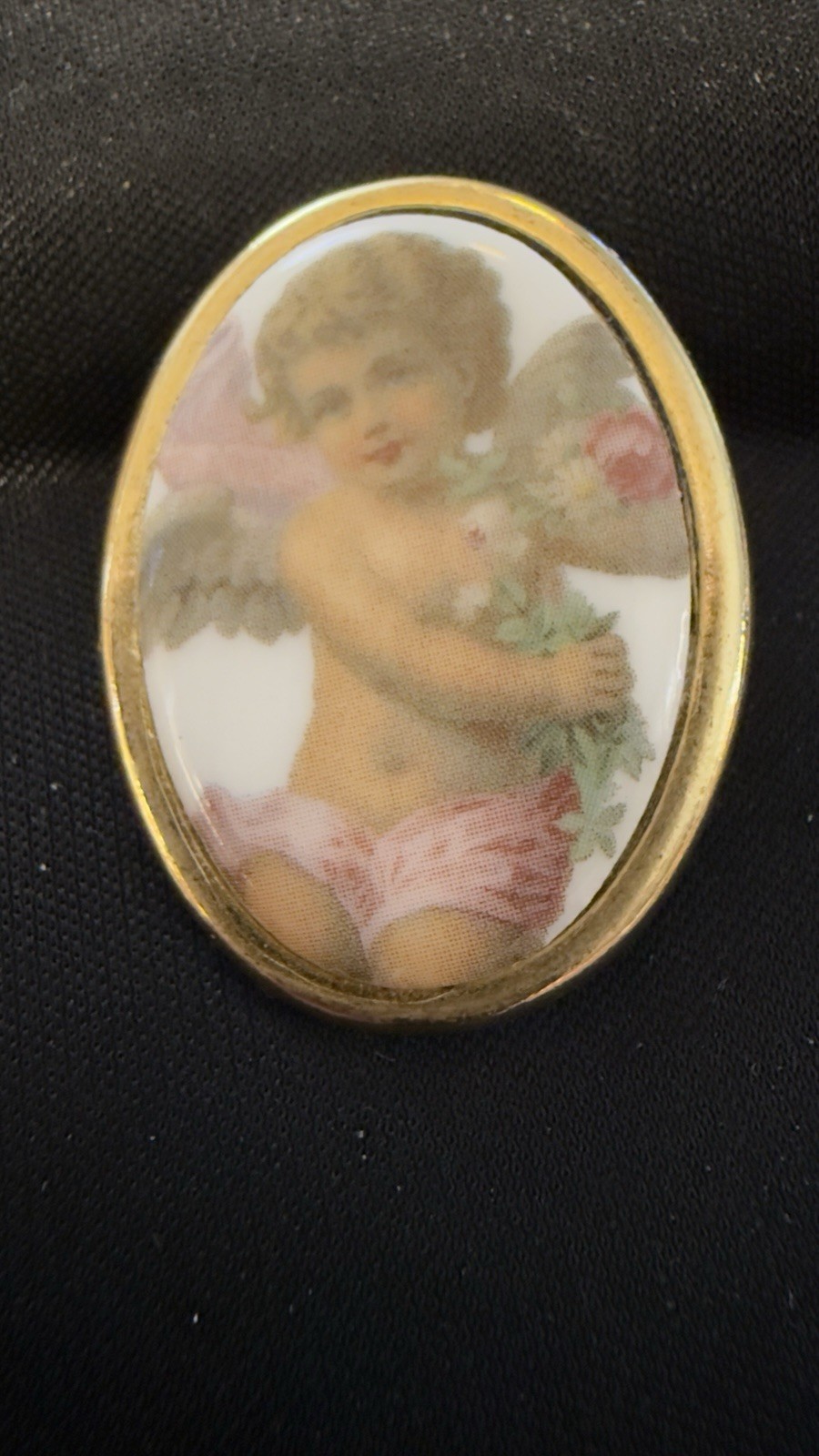 Vintage porcelain cherub or angel brooch with a gold-toned frame. 1 1/2 “