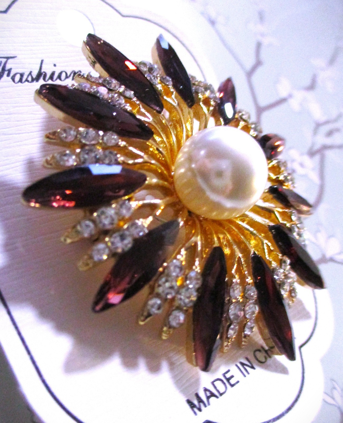 gold tone starburst brooch with purple & clear zircons + a large faux pearl