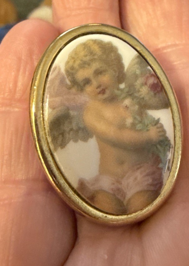Vintage porcelain cherub or angel brooch with a gold-toned frame. 1 1/2 “