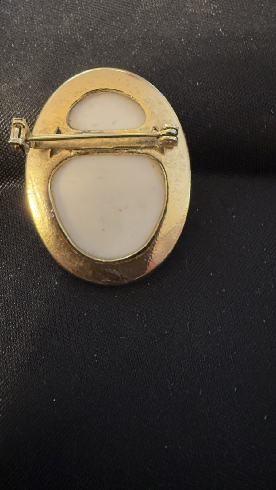 Vintage porcelain cherub or angel brooch with a gold-toned frame. 1 1/2 “