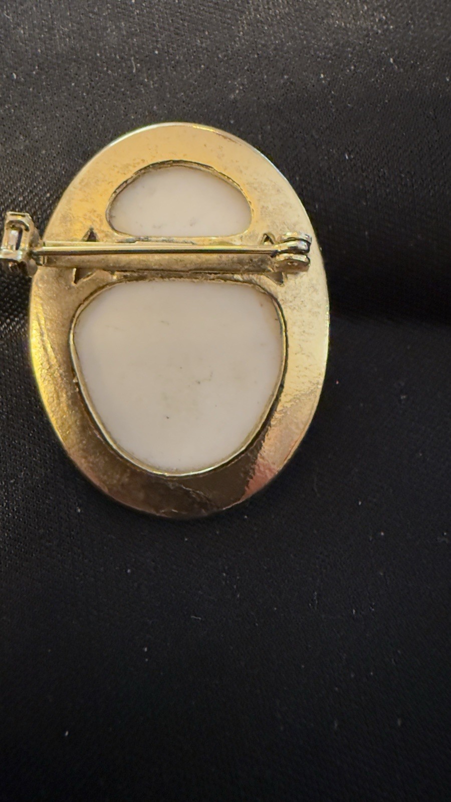 Vintage porcelain cherub or angel brooch with a gold-toned frame. 1 1/2 “